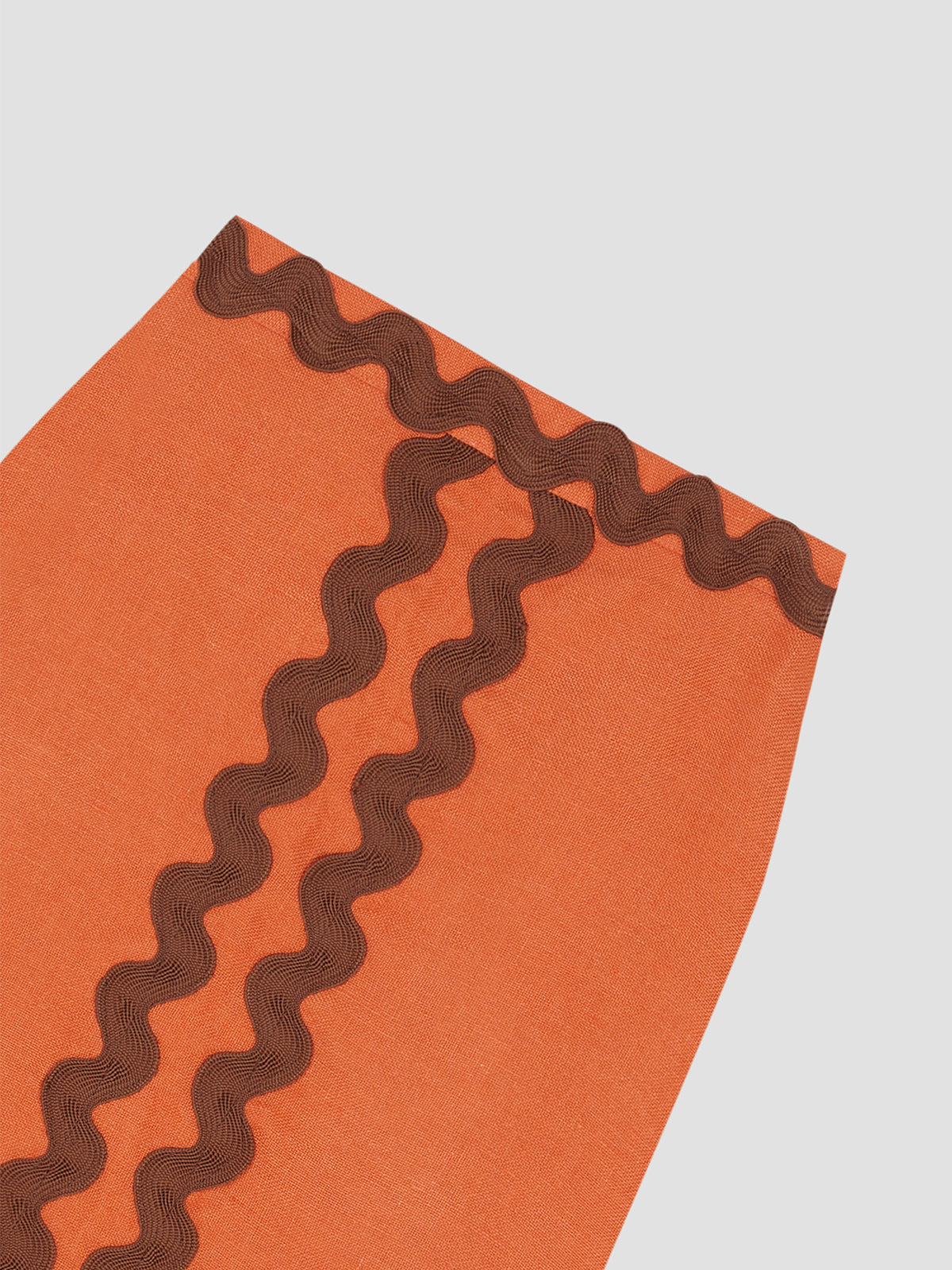 Midi skirt made in orange linen with brown trim detail