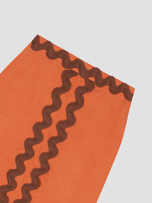 Midi skirt made in orange linen with brown trim detail