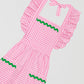 Pink vichy quilted apron with front pockets and green trim on skirt and pockets.