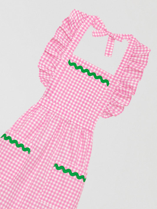 Pink vichy quilted apron with front pockets and green trim on skirt and pockets.