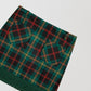 Plaid mini skirt in green, red and yellow with fringed detail at the bottom. 