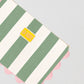 Green and white striped toiletry bag with top zipper and pink piping details 