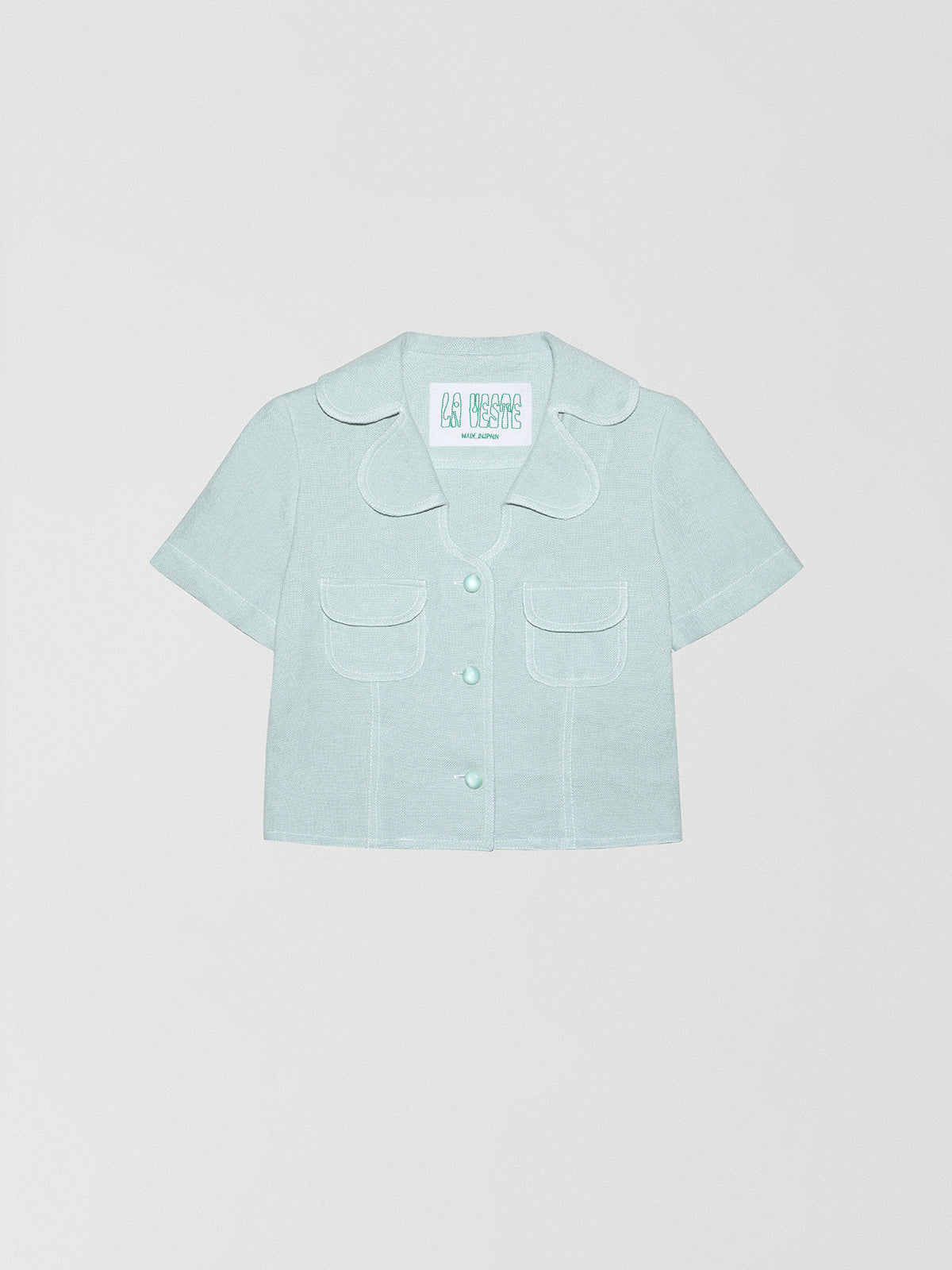 Loto Blue Shirt is a shirt made of light blue linen fabric with two pockets in the front.