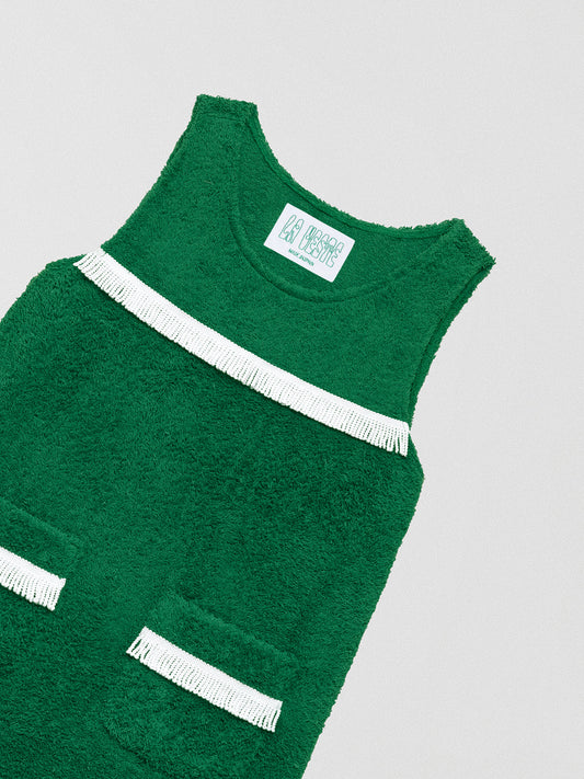 Short green dress with white fringed details on the chest and skirt