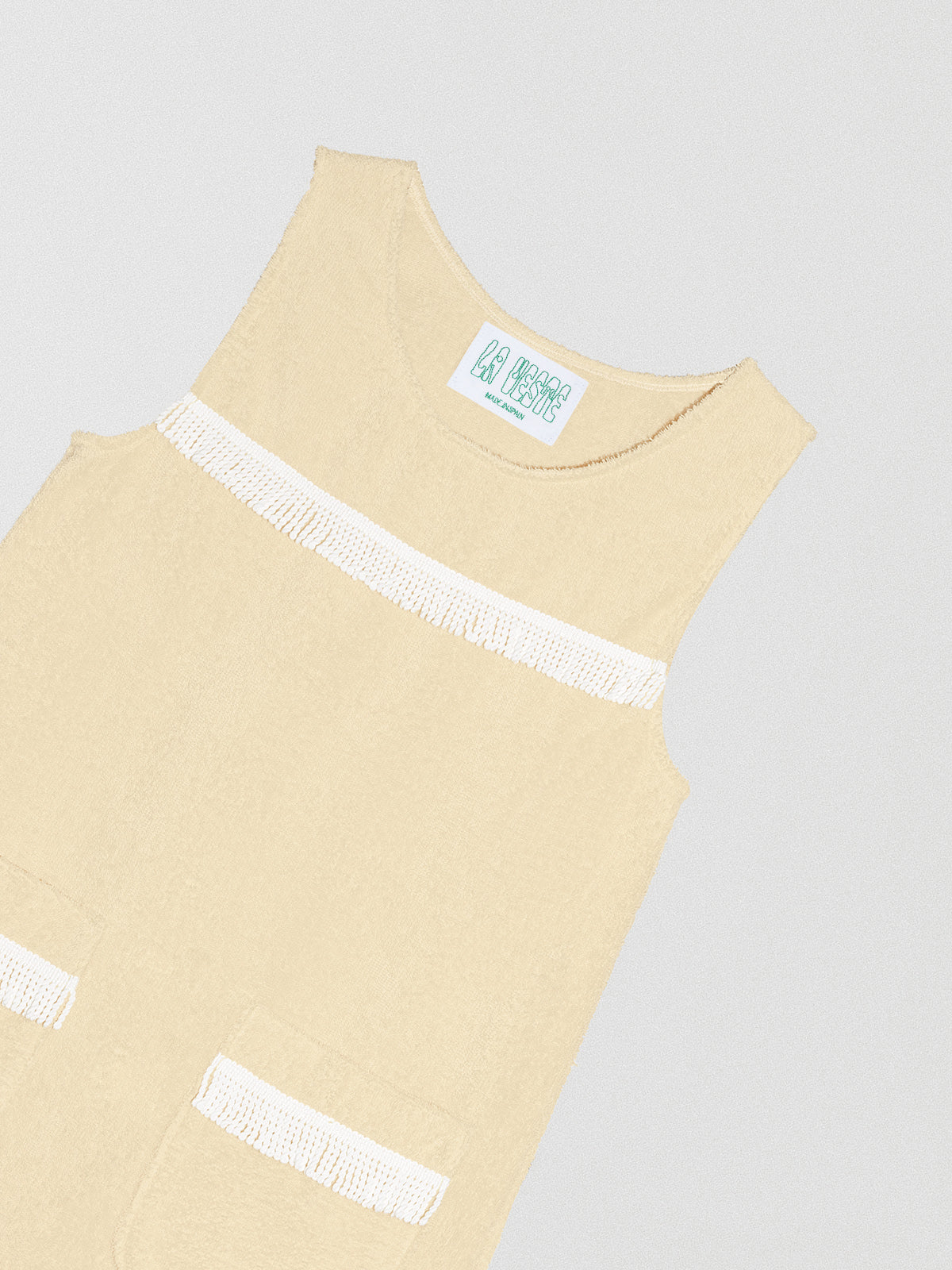 Vanilla colored dress with white fringe details on the chest and bottom