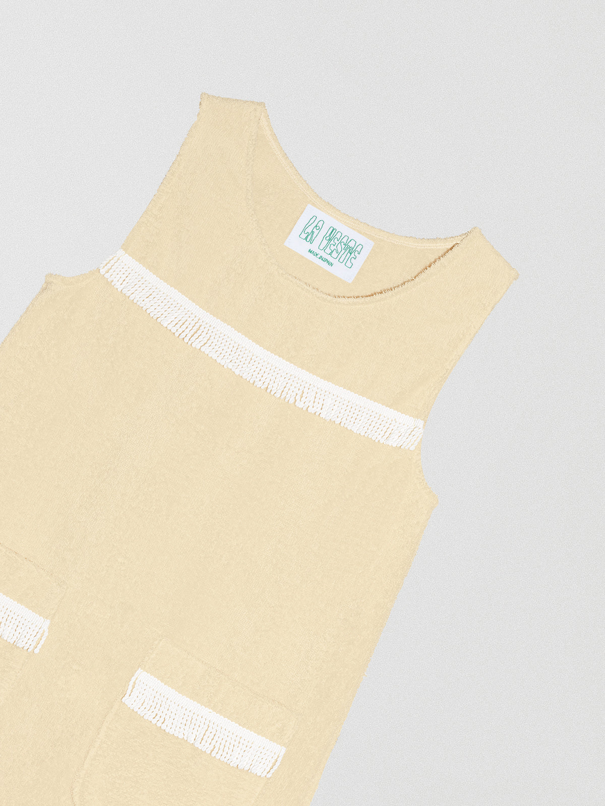 Vanilla colored dress with white fringe details on the chest and bottom