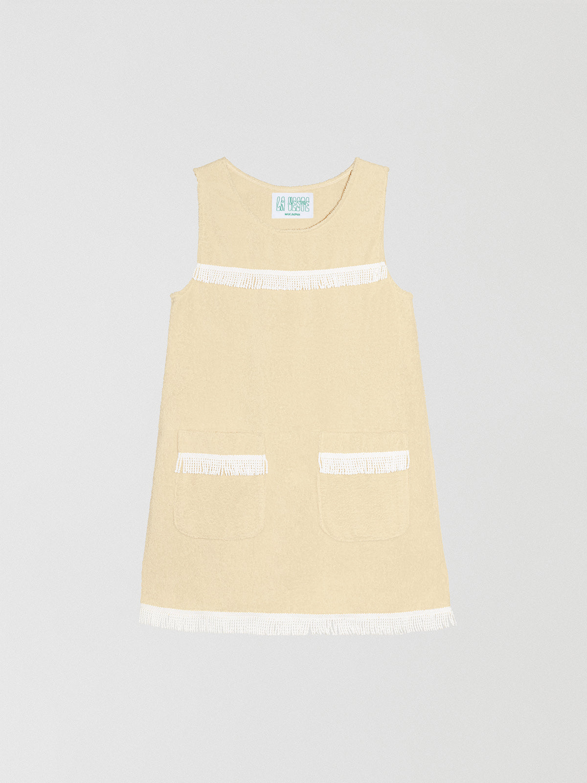 Fringes Mini Towel Vanilla is a vanilla-colored dress with two front pockets and white bangs on the chest and bottom.