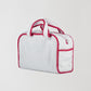 Back view of our white towel bag with red details on the edges and zipper closure.