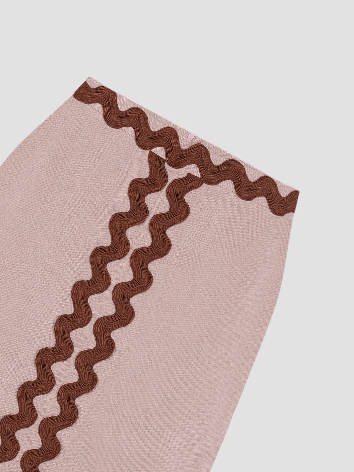 Midi skirt made in pink linen with brown trim detail