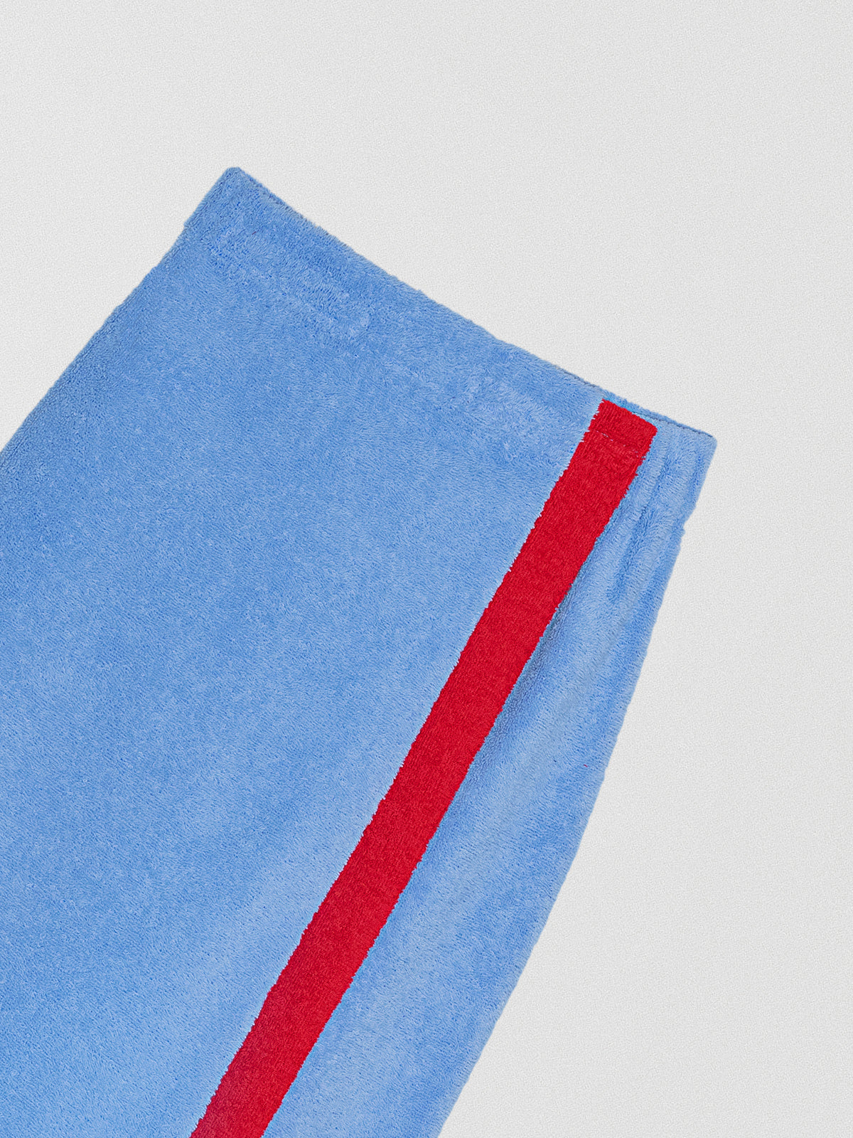 Pareo towel skirt made in blue cotton with red band.
