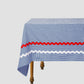 Dining table with tablecloth made of blue cotton vichy fabric with blue and white trimming 