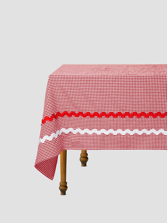 Dining table with a red vichy check tablecloth and matching red and white piping details