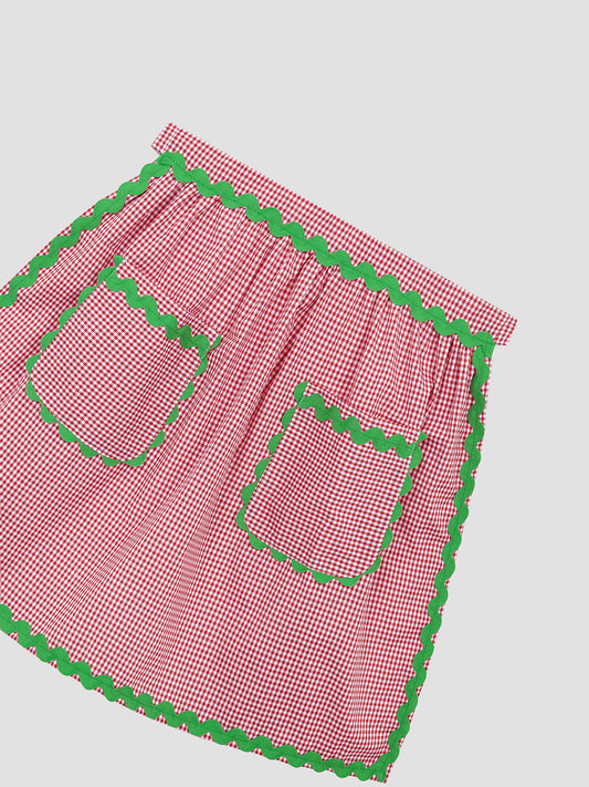 Red and white vichy quilted apron with green piping details and two matching front pockets.