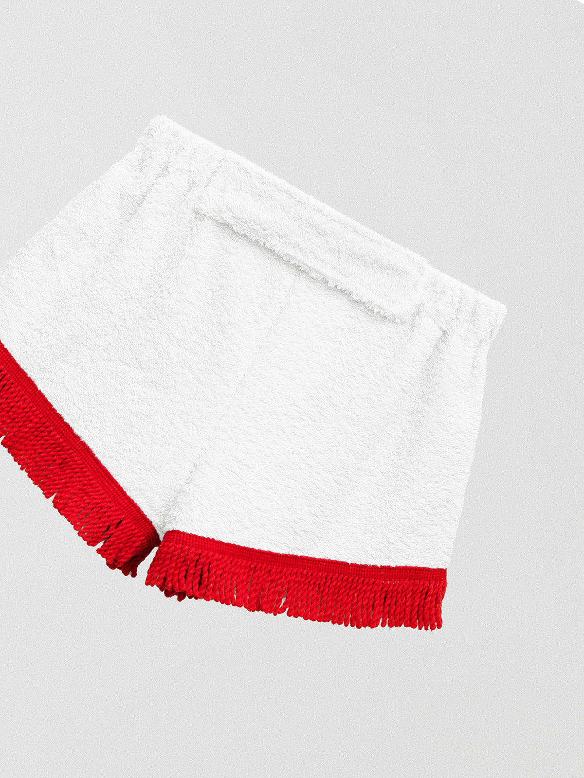 Towel shorts made in white cotton with red fringes.