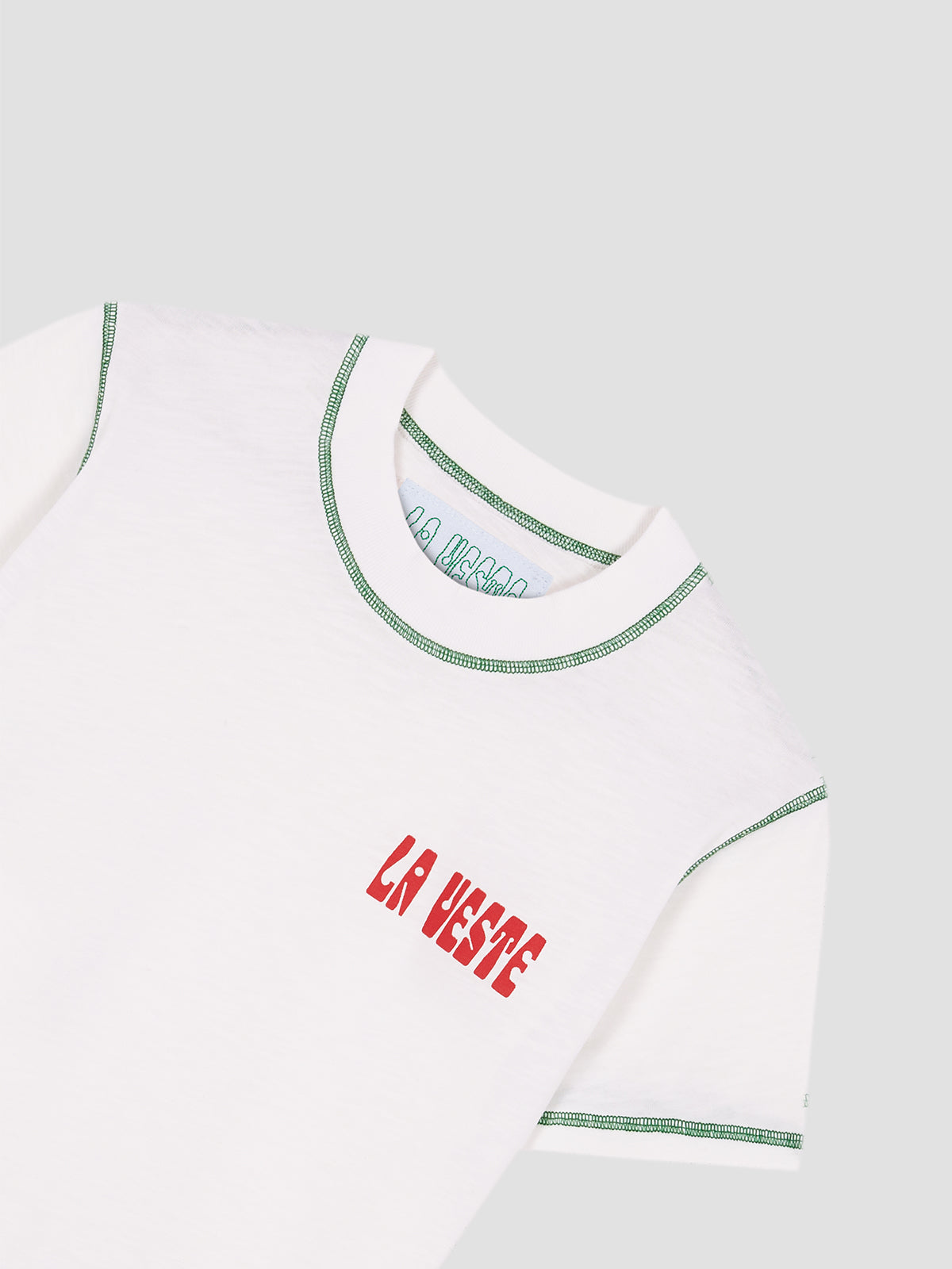 Color: White/Green. White cotton T-shirt with LA VESTE logo in red. Regular fit. Normal length. Round neck. Short sleeves. Collar and sleeve cuffs in green contrast. Anagram on the chest in red.