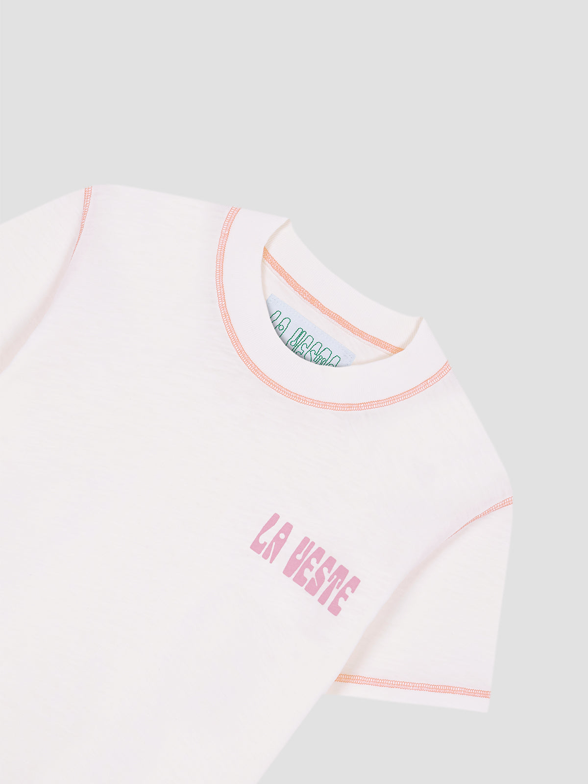 White cotton T-shirt with LA VESTE logo in fuchsia. Regular fit. Normal length. Round neck. Short sleeves. Collar and sleeve cuffs in coral contrast. Anagram on the chest in fuchsia.