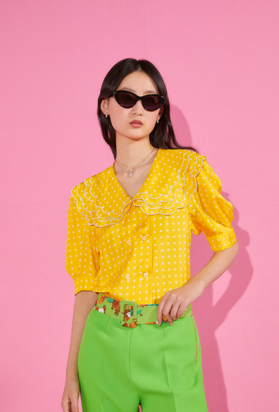 Woman with glasses, yellow shirt and green high-waisted pants