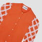 Shirt made of orange colored silk and rounded collar. It has sleeves above the elbow with raw lace detail. Button closure.