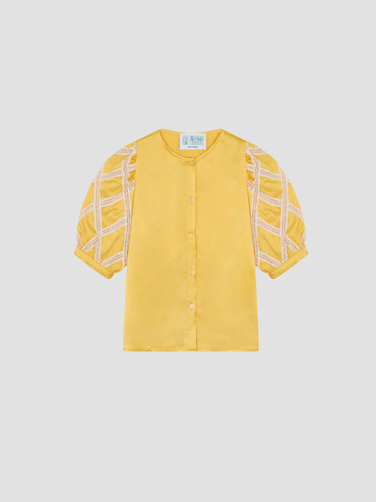 Alfresco Shirt Satin Yellow is a yellow satin shirt with puffed sleeves and lace details.