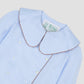 Women's long-sleeved blue shirt with brown piping details and white button front closure