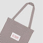 White and chocolate brown striped tote bag with La Veste logo at the top center