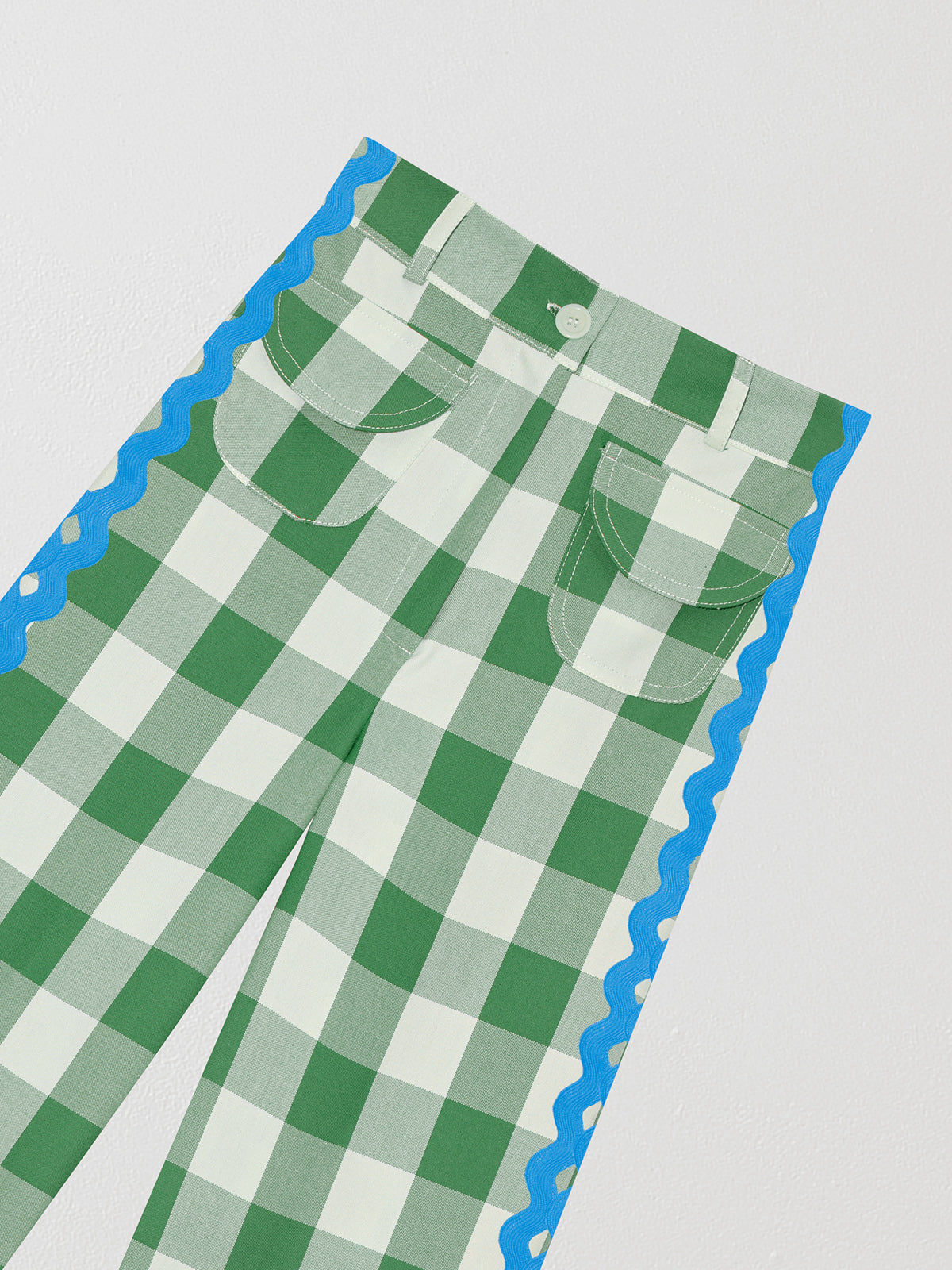 Cotton trousers with green and white check print and blue trim detail on the sides. 