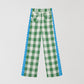 Cotton trousers with green and white check print and blue trim detail on the sides. 