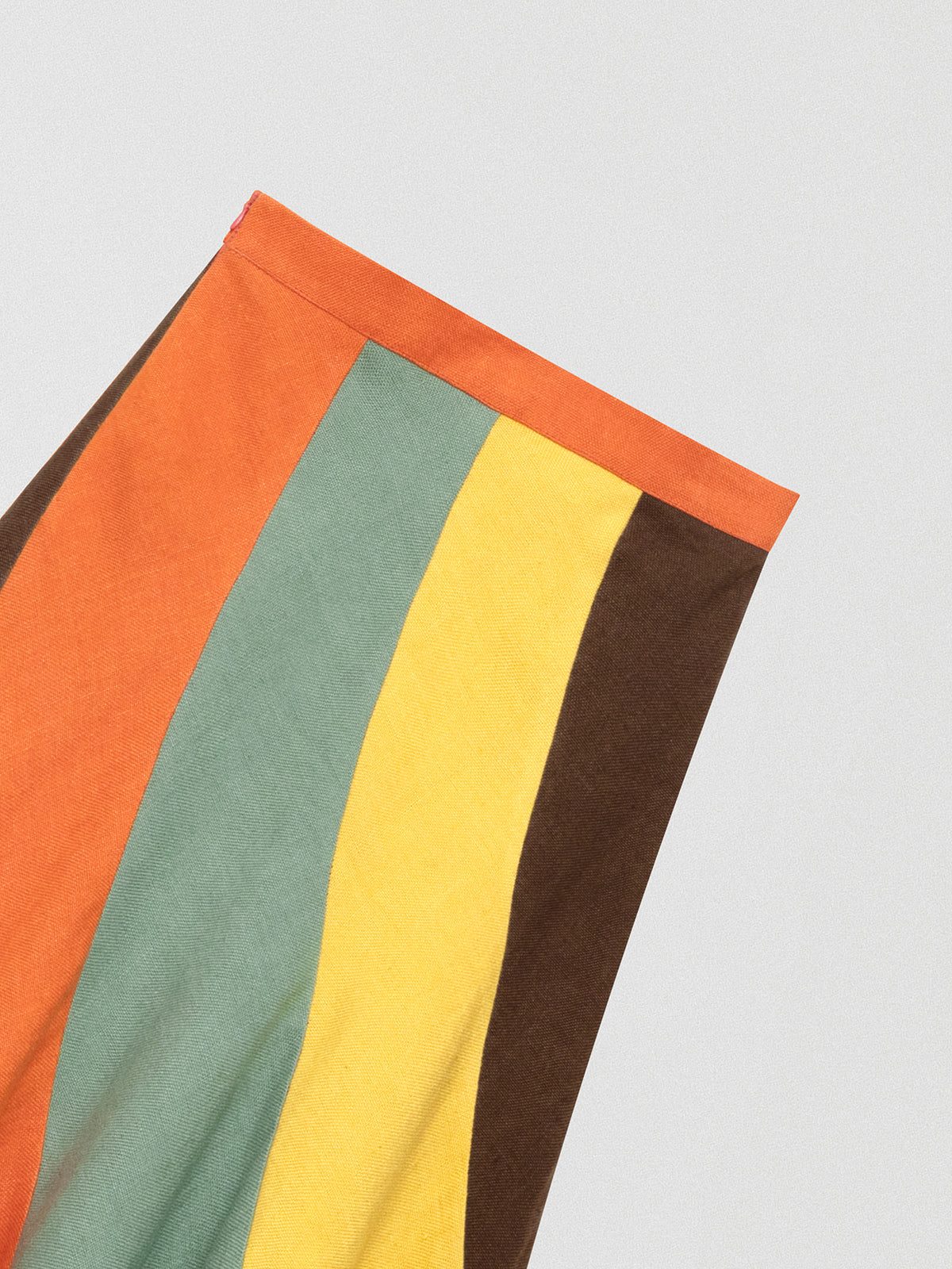 Flared linen midi skirt with asymmetric print in orange, yellow, green and brown.