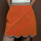 Orange mini skirt made of velvet with a wavy finish. 
