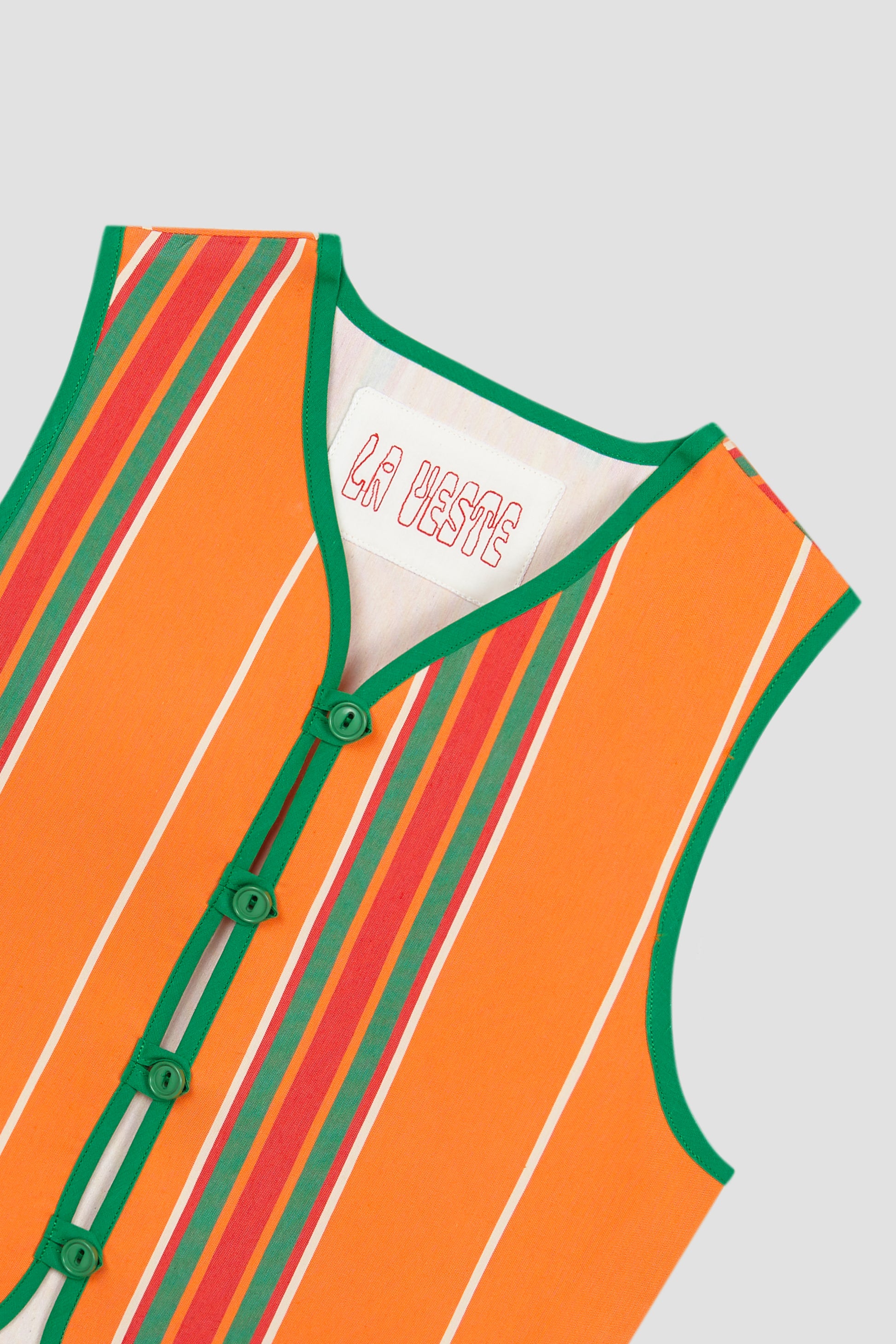 Orange cotton waistcoat with red and green stripes and green bias binding.