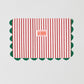 La Veste Striped Pouch 01 is a red and white striped toiletry bag with dark green piping details on the edge.