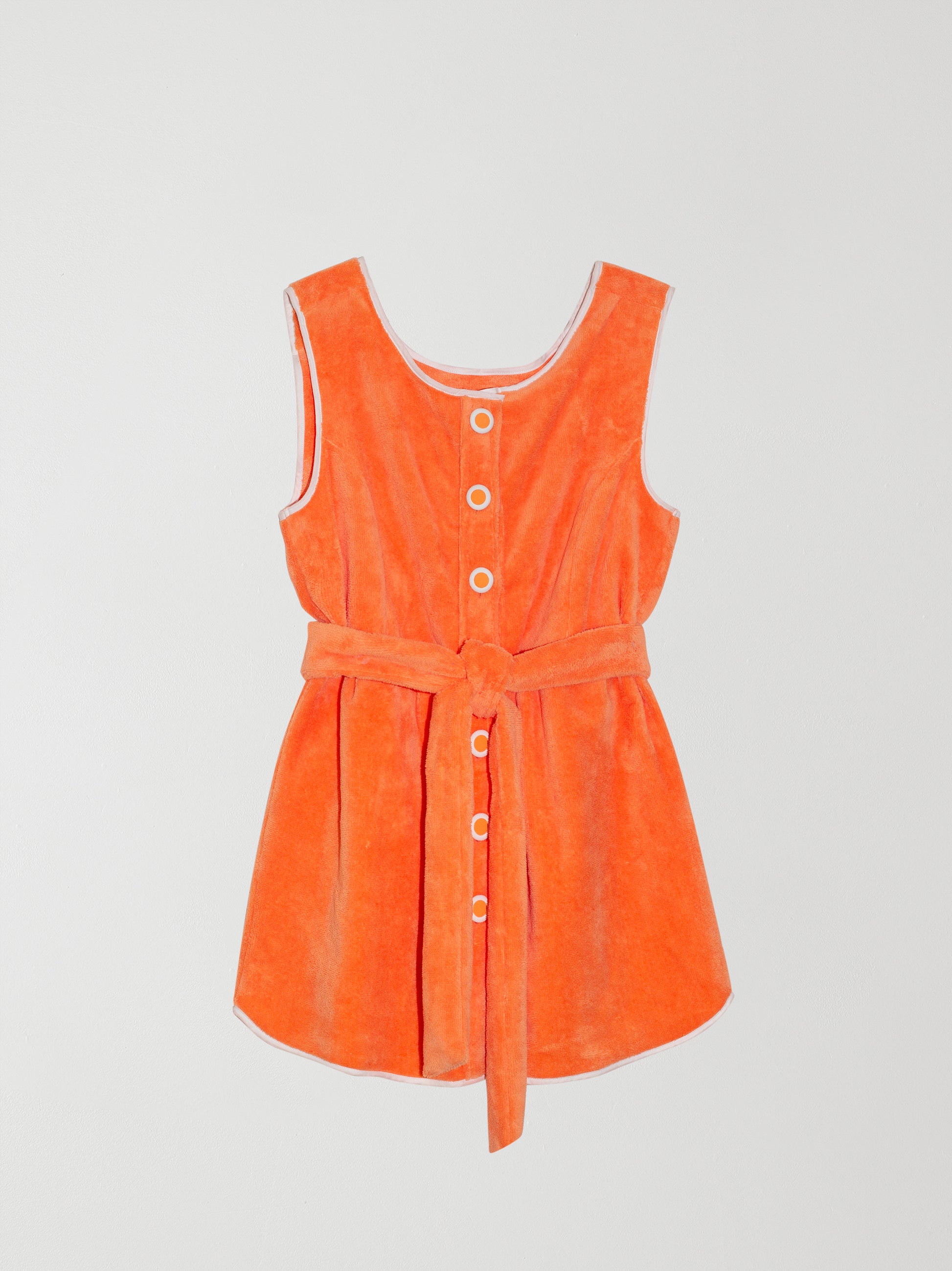 Colour: Orange.  Short towel dress made in orange cotton with white border and towel belt.   Regular fit. Short length. Sleeveless. Crew neck. Towel belt to tie at the waist.  Front fastening with white edged buttons.