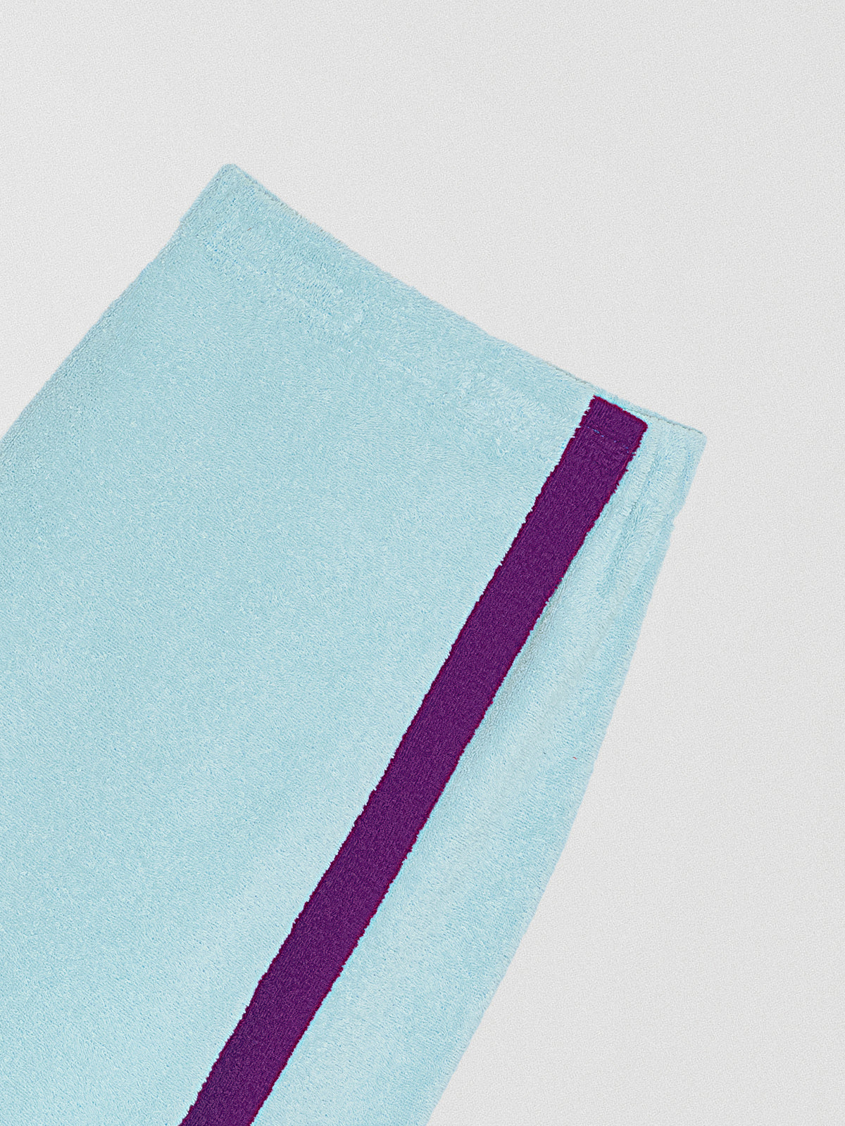 Pareo towel skirt made in blue cotton with purple band.