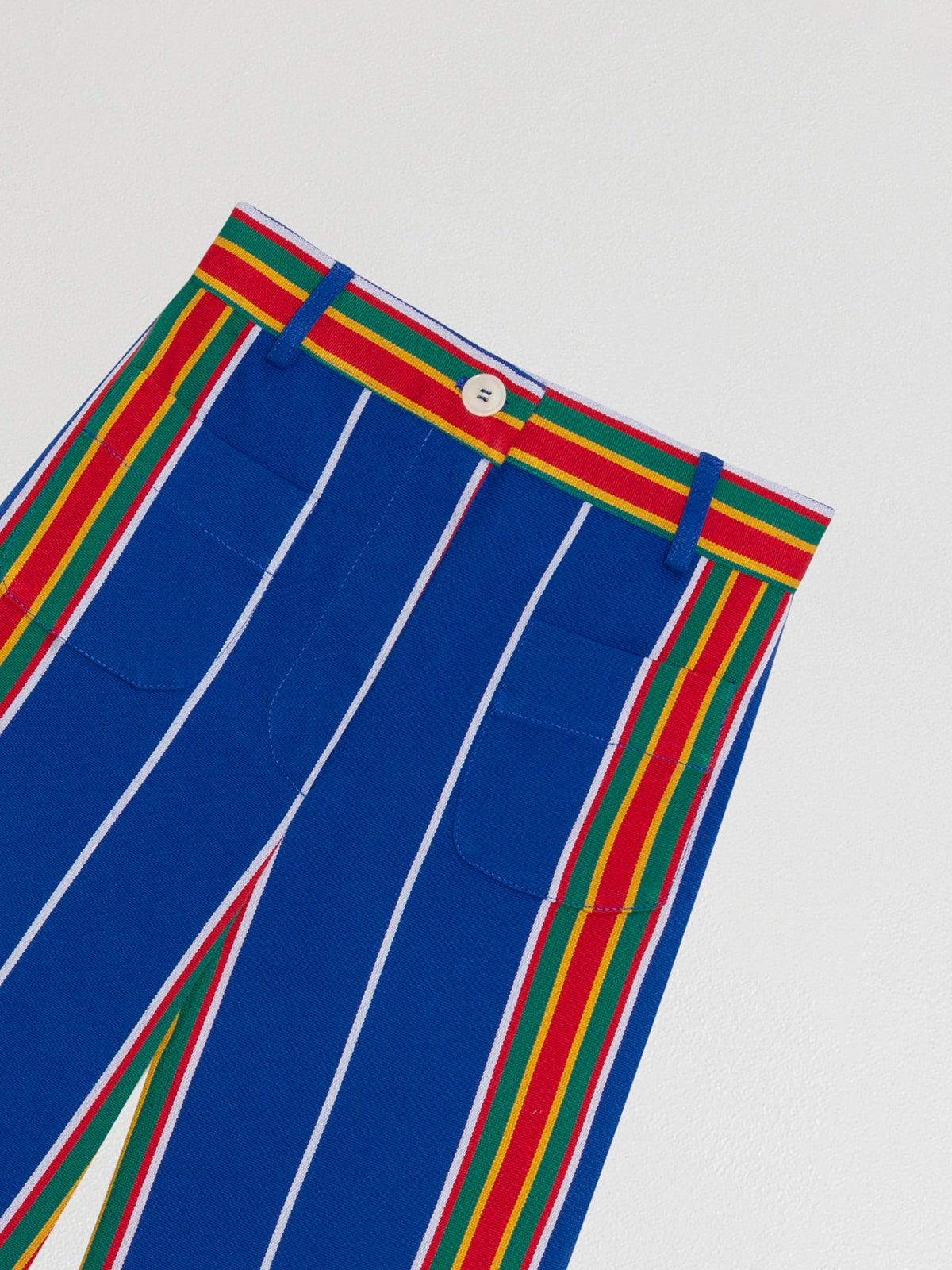 Blue high-waisted printed trousers in cotton with yellow, red and green stripes. 