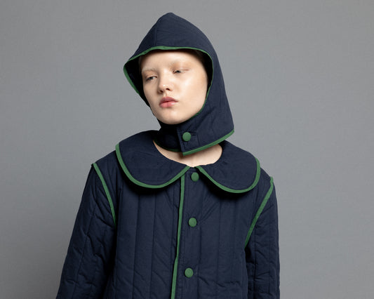 Close-up view of our navy quilted hood with green piping details