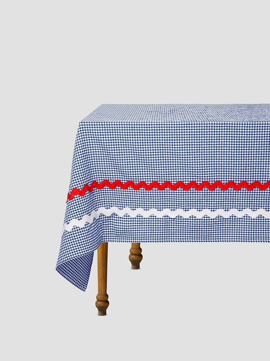 Dining table with tablecloth made of blue cotton vichy fabric with blue and white trimming 