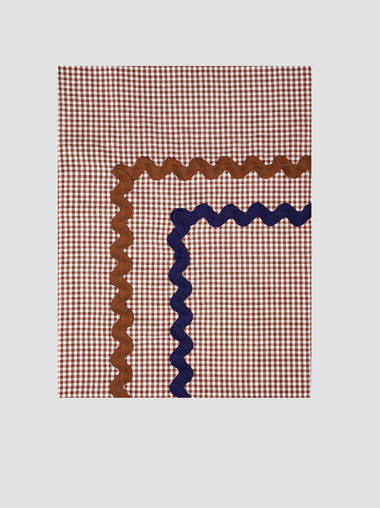 Tableclotha Mini Check Brown is a rectangular brown vichy check tablecloth with brown and blue trim.