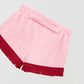 Towel shorts made in pink cotton with red fringes. 