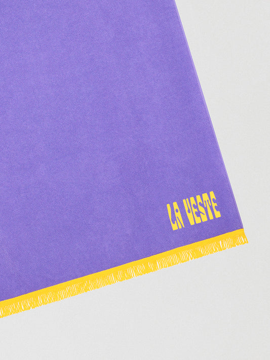 Towel made in purple cotton with yellow fringes detail. 