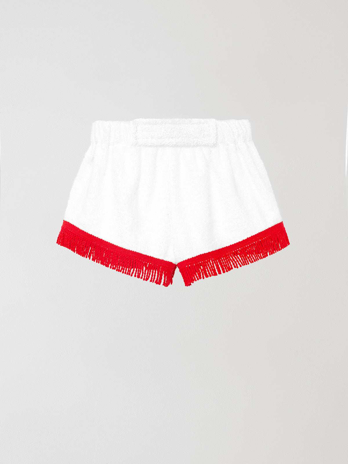 Towel shorts made in white cotton with red fringes. 